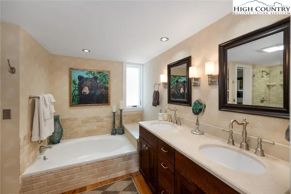 a bathroom with a double vanity sink a mirror and a bathtub