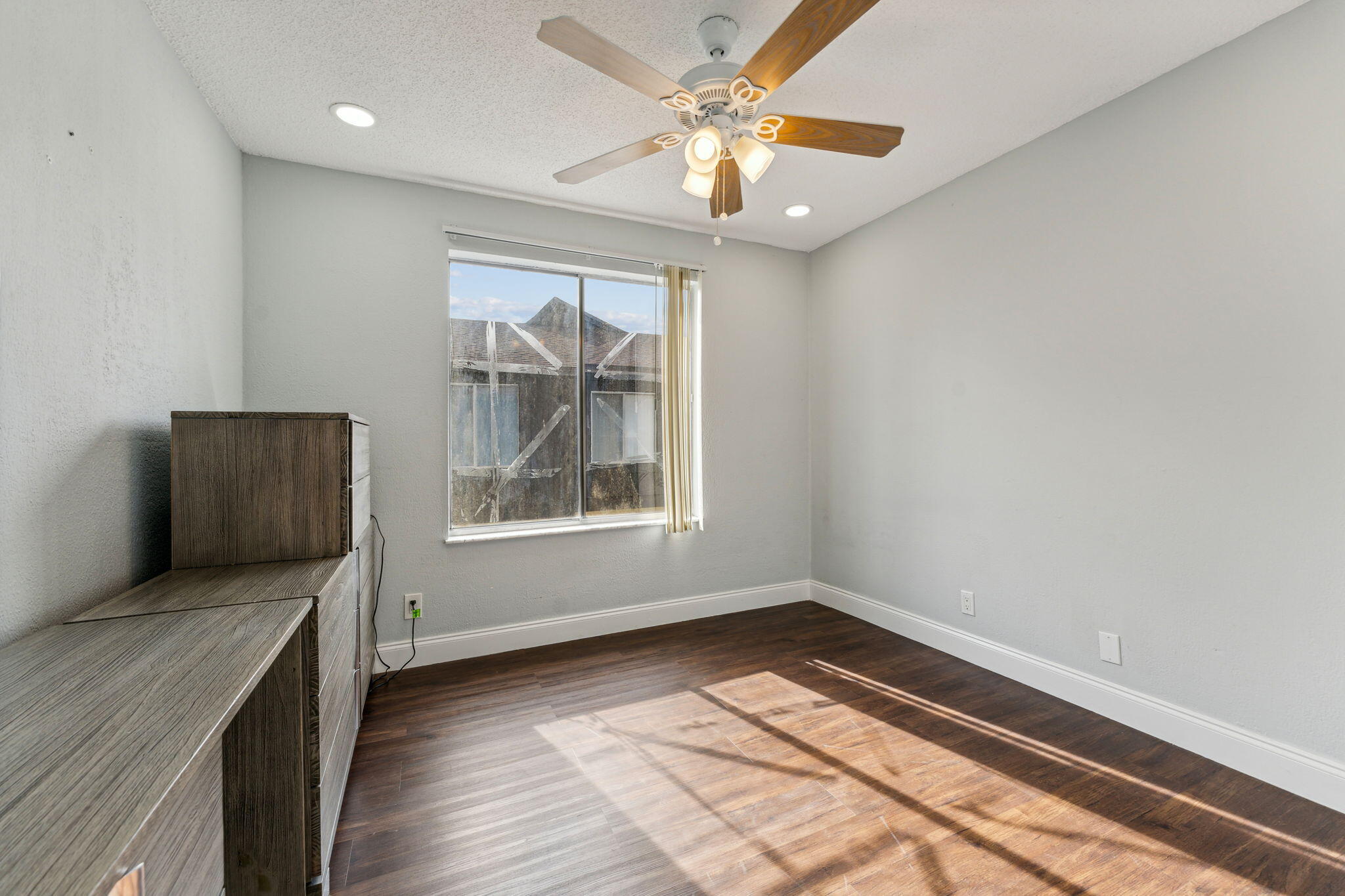 5312 Bosque Lane, Unit 80 West Palm Beach, FL 33415 - Photo 12 of 20 an empty room with wooden floor cabinet and windows