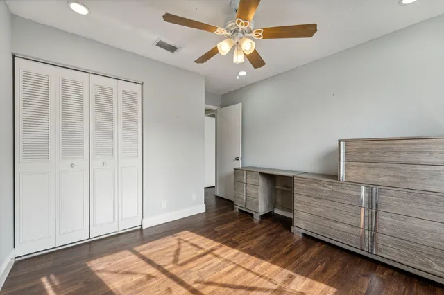 a bedroom with a bed and a ceiling fan