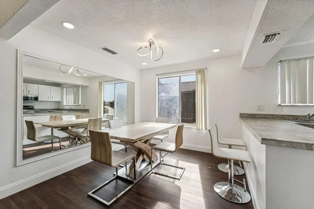 a living room with furniture a table and kitchen view