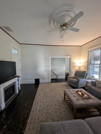 a view of a hallway with a livingroom and furniture