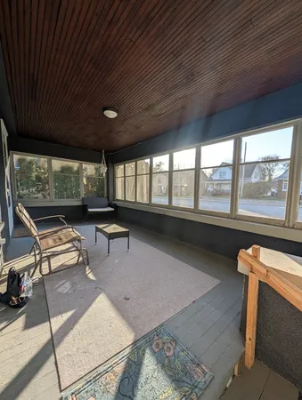 a view of a hallway with wooden floor and a window