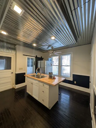 a kitchen with stainless steel appliances a sink a stove and white cabinets
