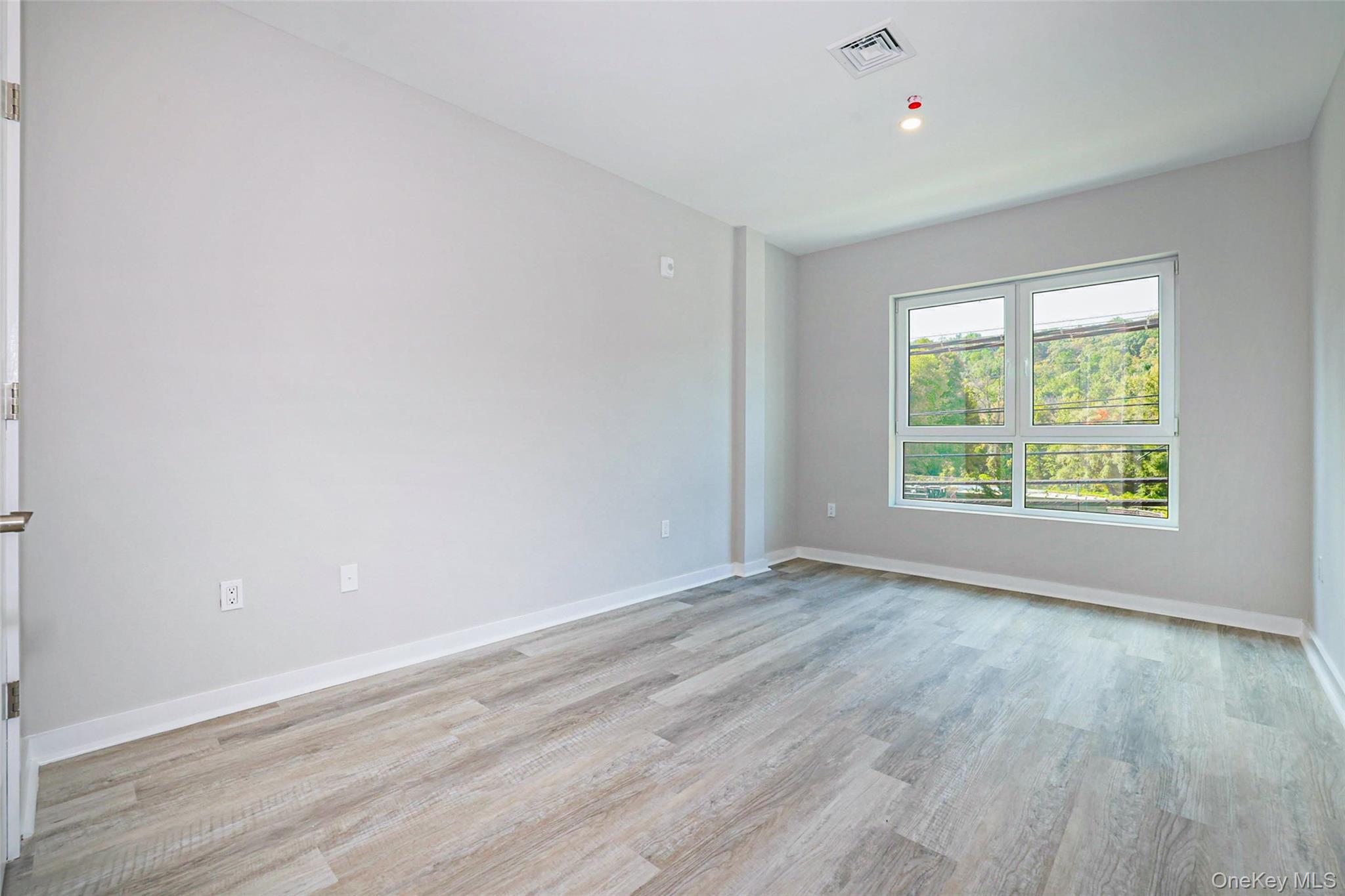 500 Commerce Street, Unit 108 Hawthorne, NY 10532 - Photo 5 of 17 Empty room with baseboards and light wood-type flooring