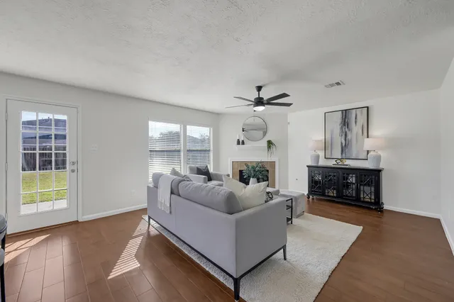 a living room with furniture and a ceiling fan