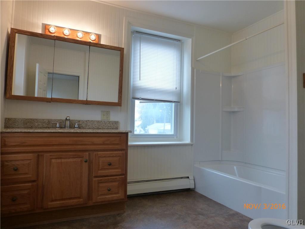 116 South Main Street Alburtis, PA 18011 - Photo 21 of 30 a bathroom with a granite countertop sink mirror and bathtub