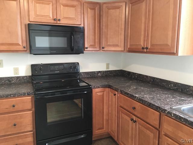116 South Main Street Alburtis, PA 18011 - Photo 23 of 30 a kitchen with granite countertop wood cabinets and stainless steel appliances