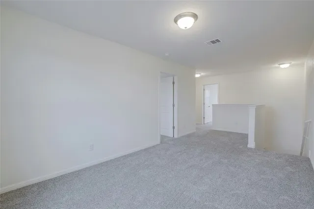 an empty room with a window and a kitchen