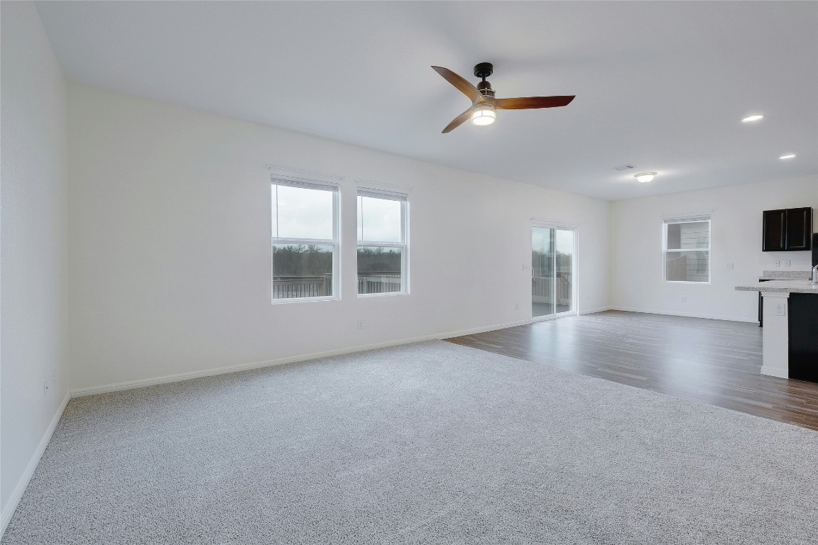 140 Satsuma Lane Kyle, TX 78640 - Photo 7 of 30 an empty room with a ceiling fan and windows