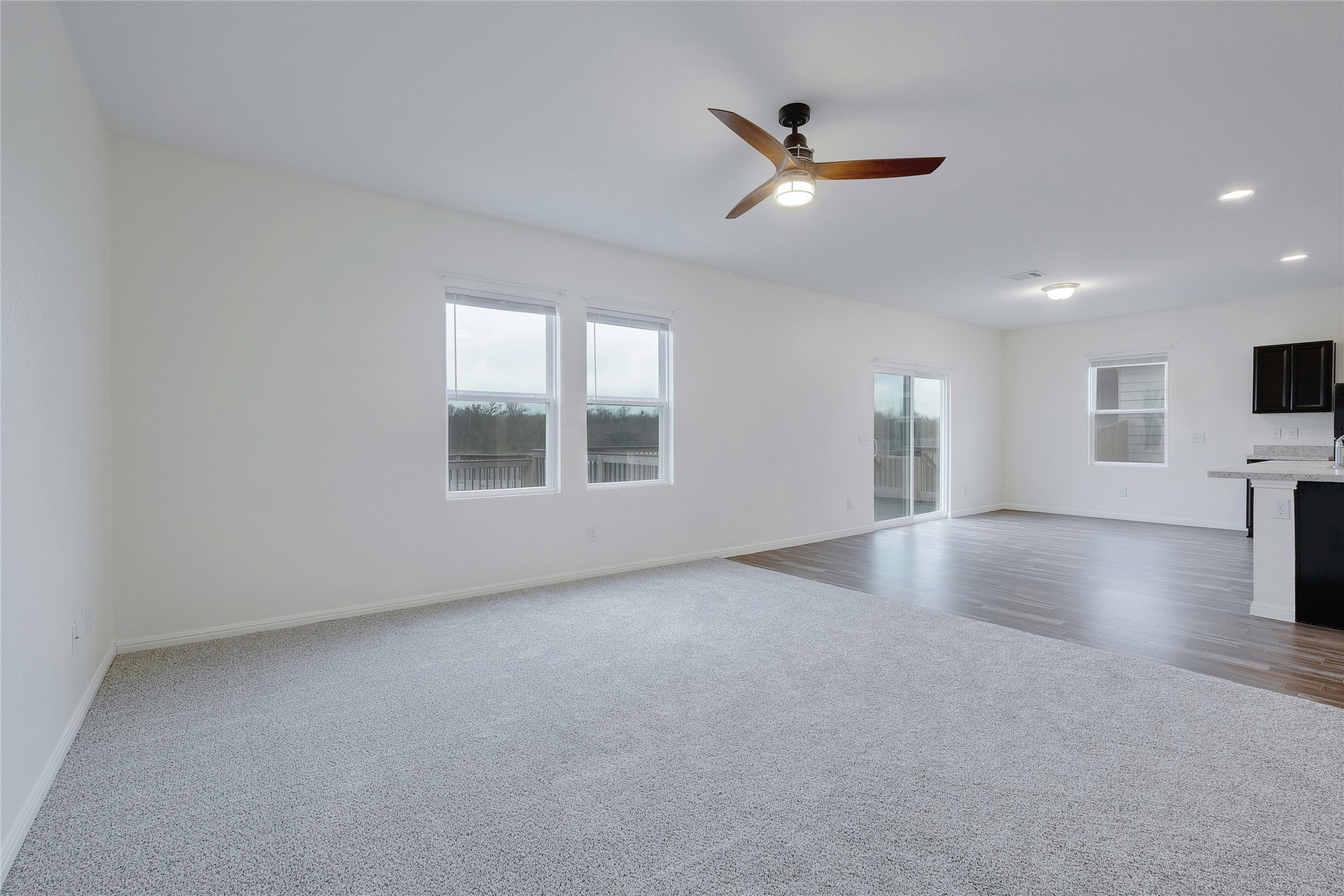 140 Satsuma Lane Kyle, TX 78640 - Photo 7 of 30 an empty room with a ceiling fan and windows