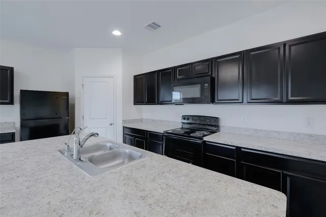 a kitchen with granite countertop wooden cabinets and stainless steel appliances