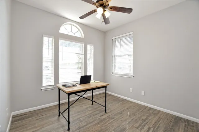 a workspace with wooden floor and windows