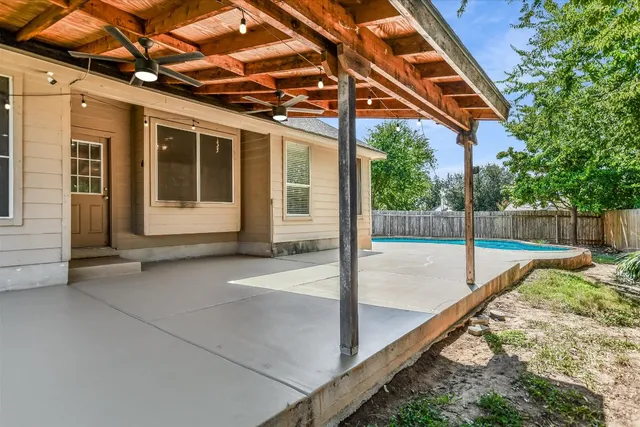 a view of a house with a sink and floor to ceiling window and wooden fence