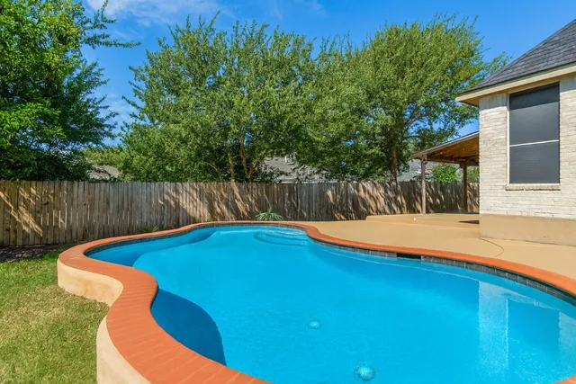 a view of a swimming pool in the backyard of house