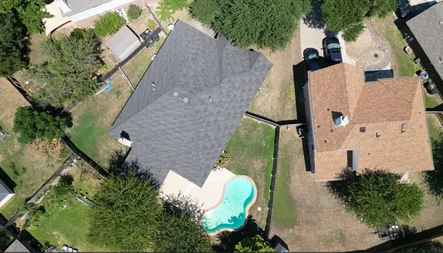 an aerial view of a house with a yard and furniture
