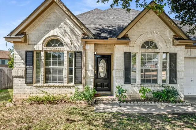 a view of a white house with large windows and a small yard