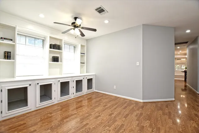 a view of an empty room with a window and wooden floor