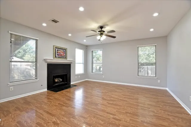 a view of empty room with a fireplace and windows