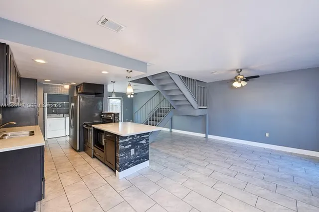 an open kitchen with refrigerator and windows