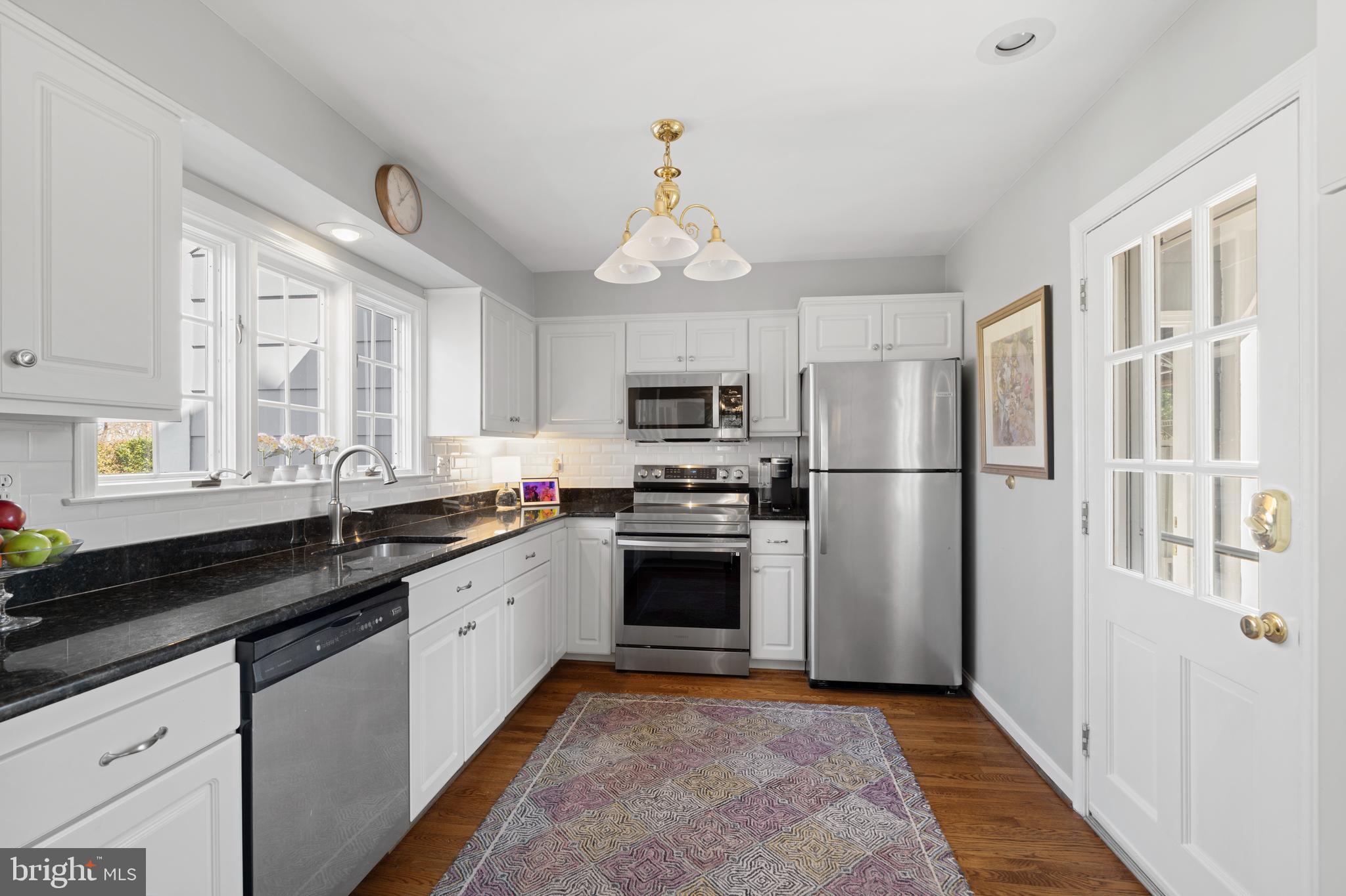 13714 Harcum Road Phoenix, MD 21131 - Photo 20 of 61 a kitchen with stainless steel appliances granite countertop a refrigerator a sink dishwasher a oven with white cabinets and wooden floor
