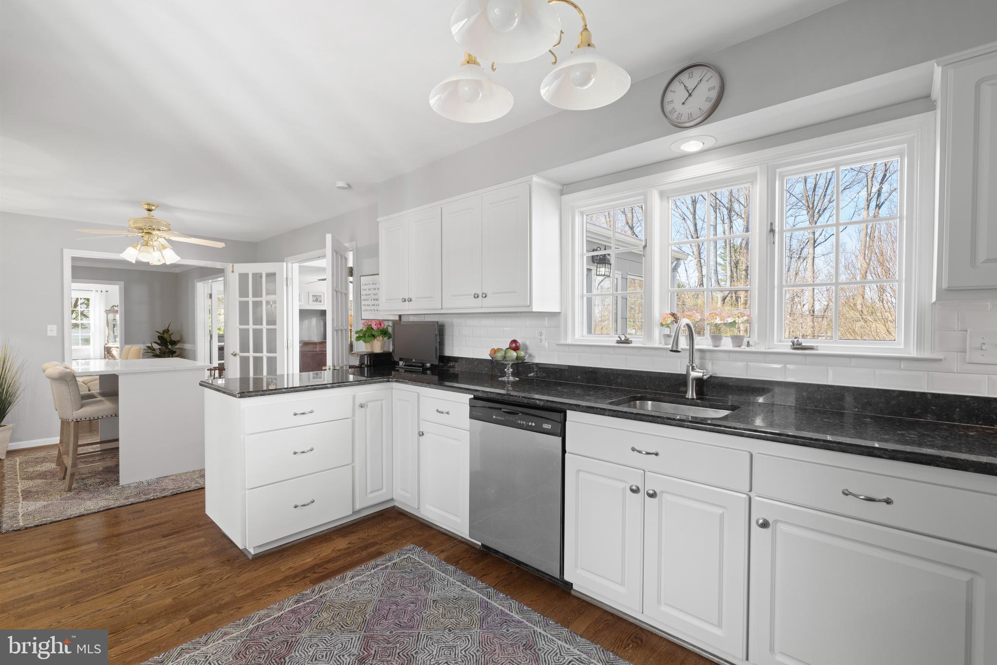 13714 Harcum Road Phoenix, MD 21131 - Photo 21 of 61 a kitchen with granite countertop white cabinets white appliances with a large window and wooden floor
