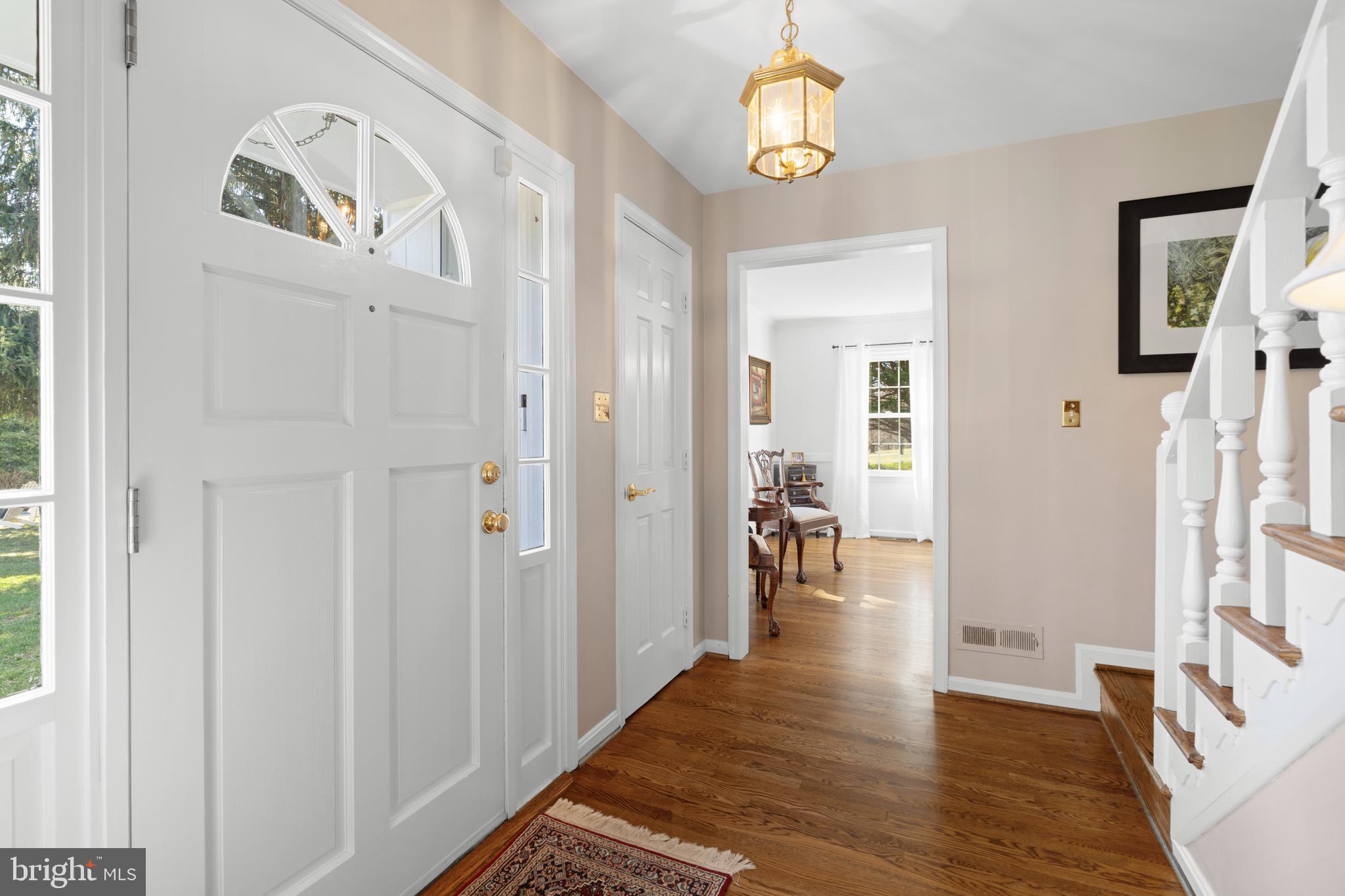 13714 Harcum Road Phoenix, MD 21131 - Photo 7 of 61 a view of a hallway to a livingroom with wooden floor and dining room