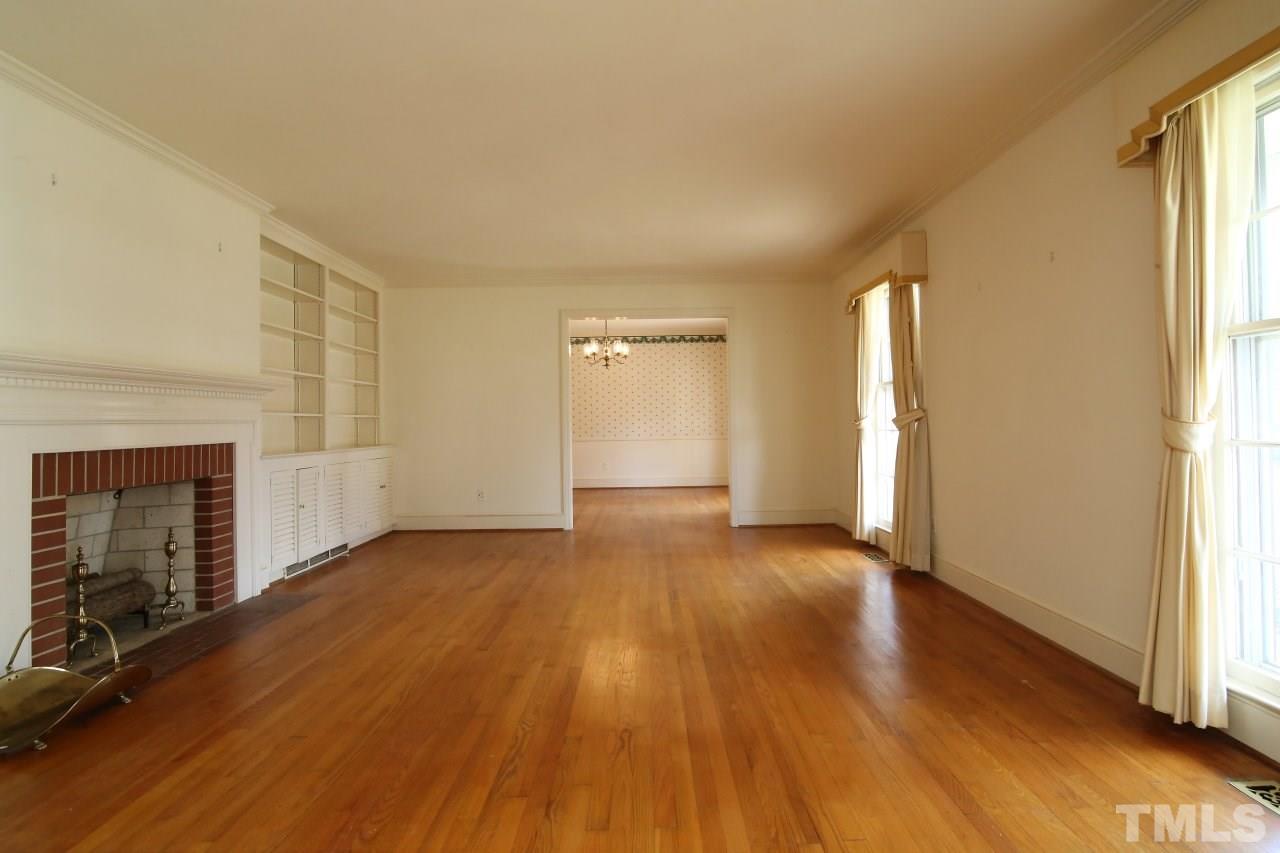 516 Chesterfield Road Raleigh, NC 27608 - Photo 4 of 21 a view of an empty room with wooden floor and a window