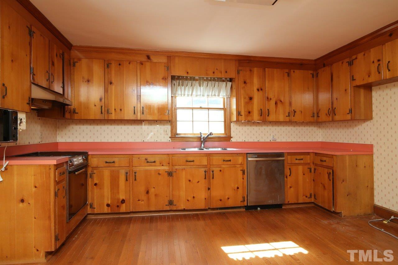 516 Chesterfield Road Raleigh, NC 27608 - Photo 8 of 21 a kitchen with granite countertop wood cabinets stainless steel appliances a sink and a window