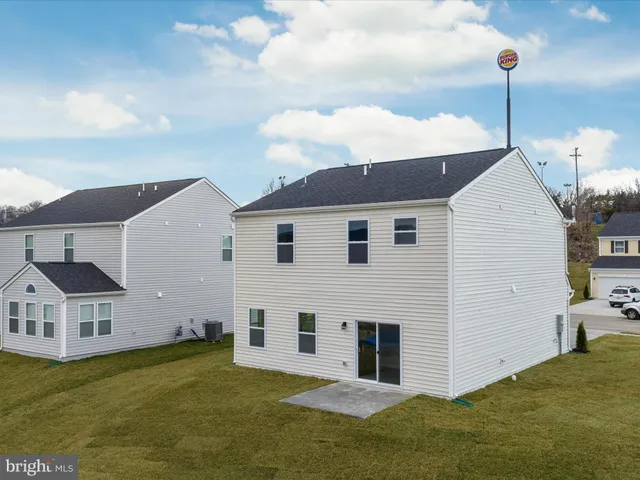a view of a white house with a big yard and large trees