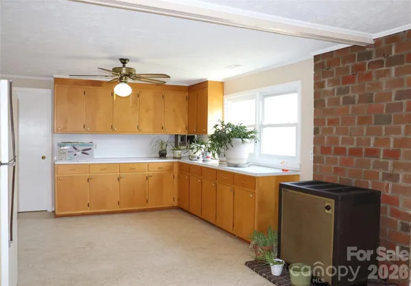 a kitchen with stainless steel appliances a sink a stove a refrigerator cabinets and a window