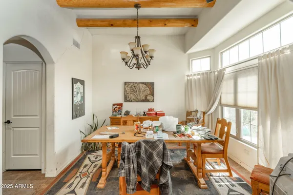 a view of a dining room with furniture a chandelier and wooden floor