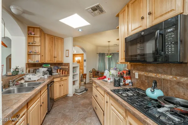 a kitchen with stainless steel appliances kitchen island granite countertop a sink stove and cabinets