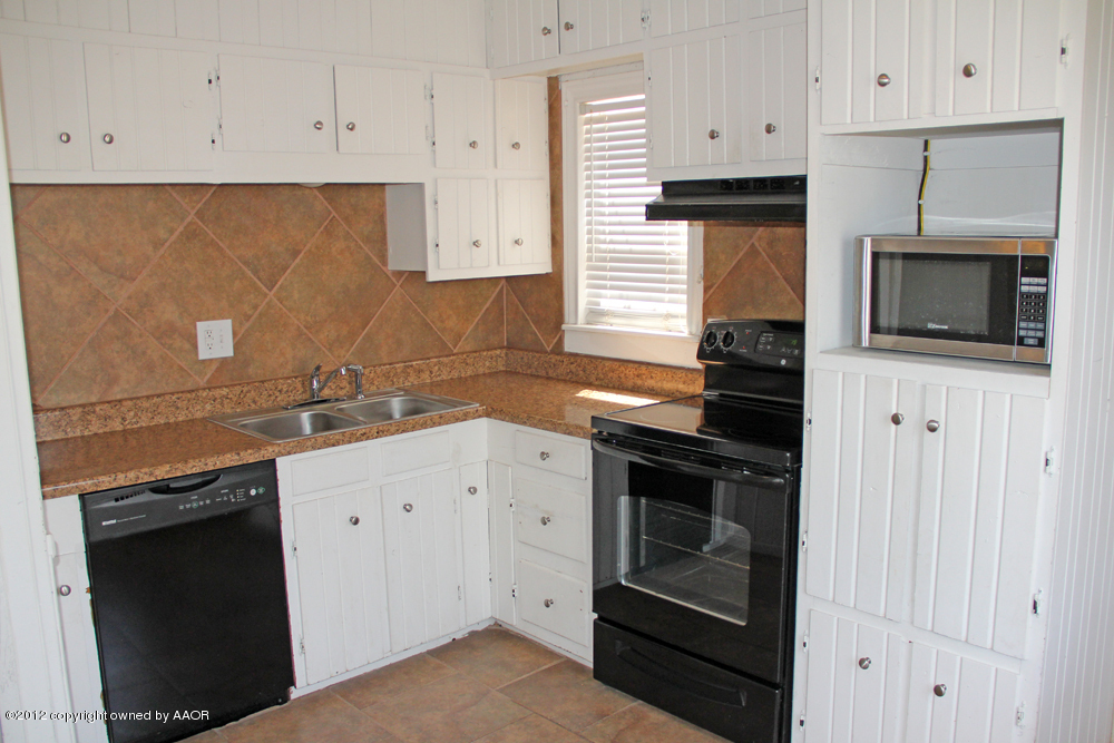 4306 South Hayden Street Amarillo, TX 79110 - Photo 7 of 23 a kitchen with granite countertop white cabinets stainless steel appliances and sink