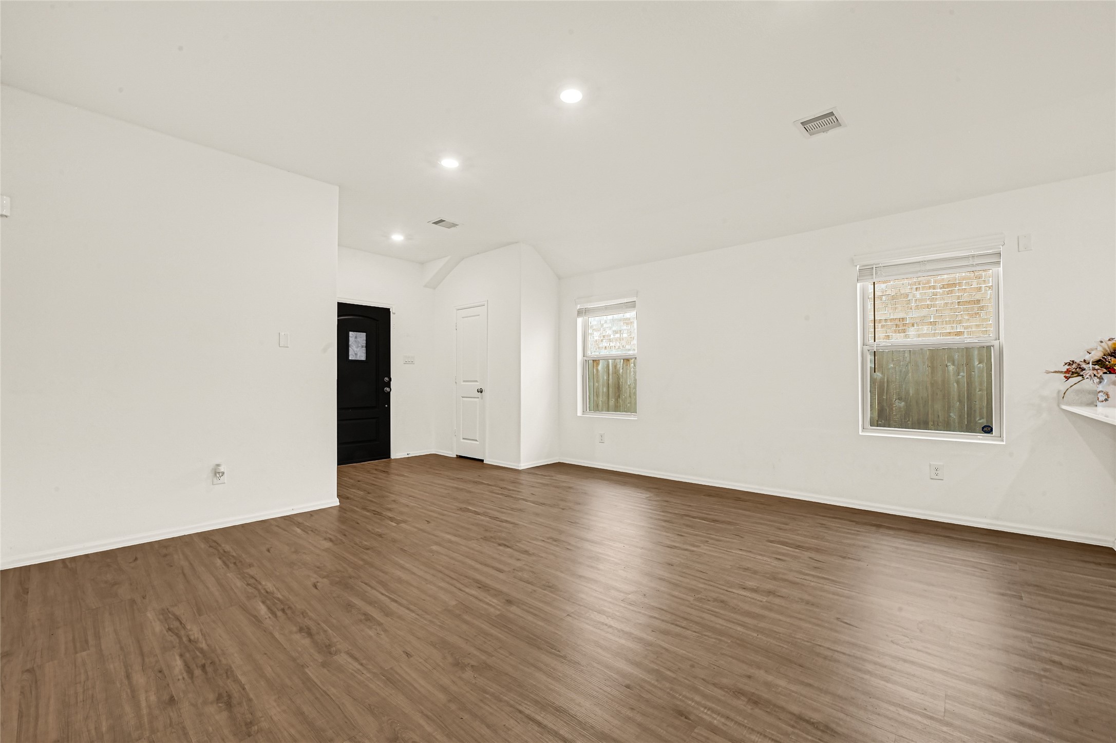 2010 Ballesteros Street Crosby, TX 77532 - Photo 4 of 24 an empty room with wooden floor and windows