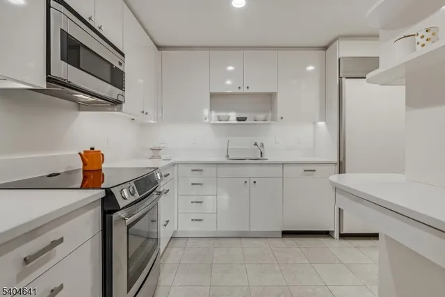 a kitchen with stainless steel appliances white cabinets and a sink