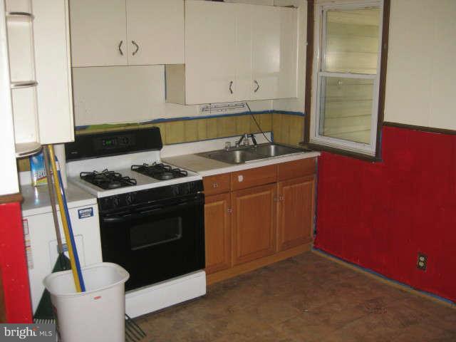 8232 Cornwall Road Baltimore, MD 21222 - Photo 6 of 14 a kitchen with stainless steel appliances granite countertop a sink stove and cabinets