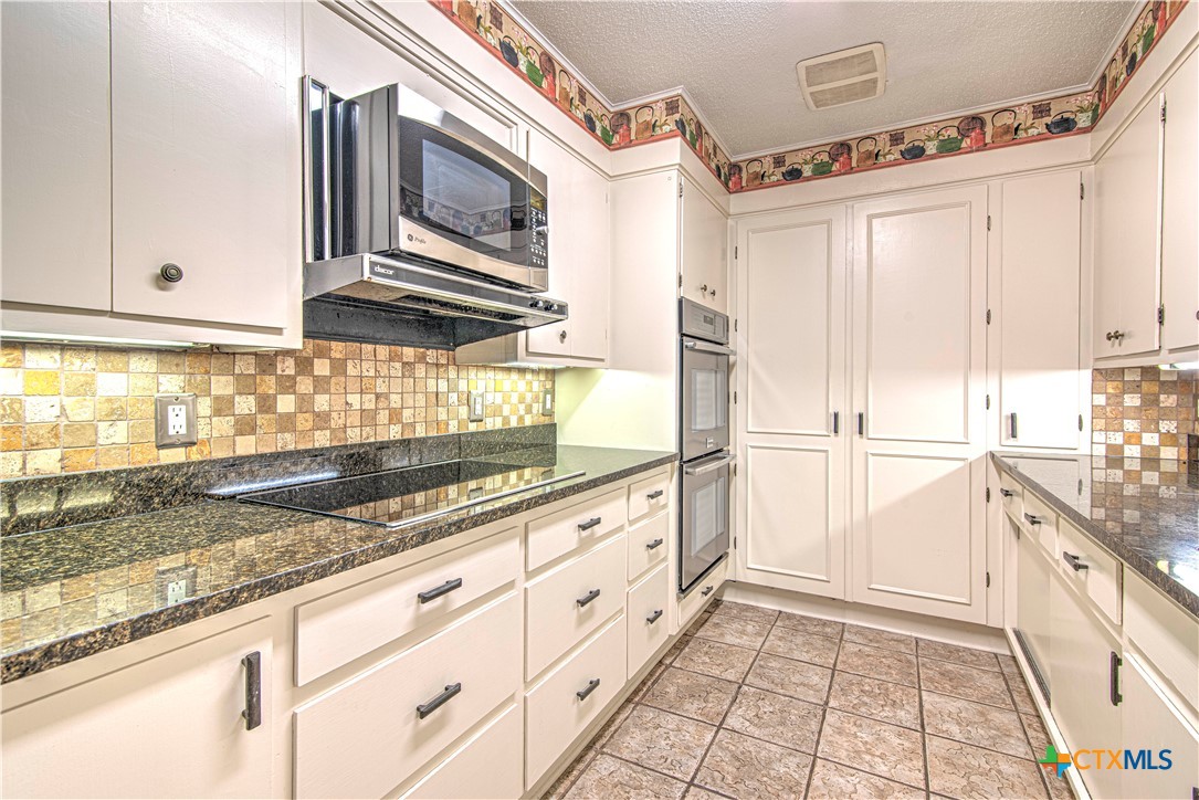 2701 Wren Circle Temple, TX 76502 - Photo 12 of 48 a kitchen with granite countertop white cabinets and white appliances