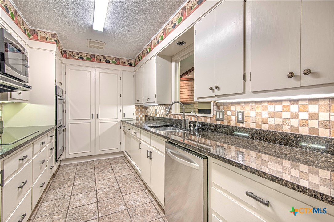 2701 Wren Circle Temple, TX 76502 - Photo 13 of 48 a kitchen with granite countertop a sink stove and cabinets