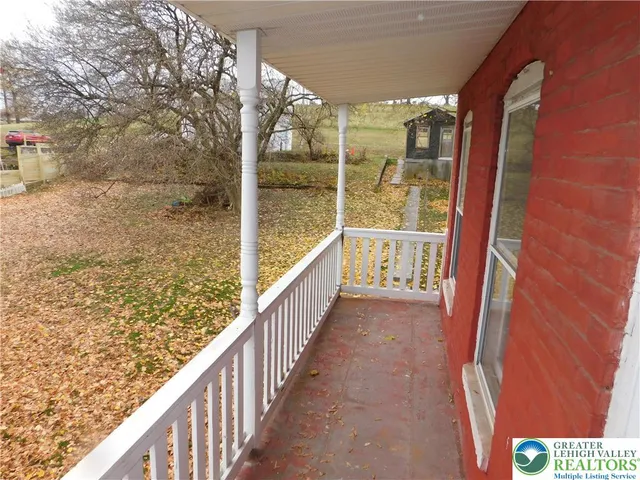 a view of a lake with table and chairs under an umbrella