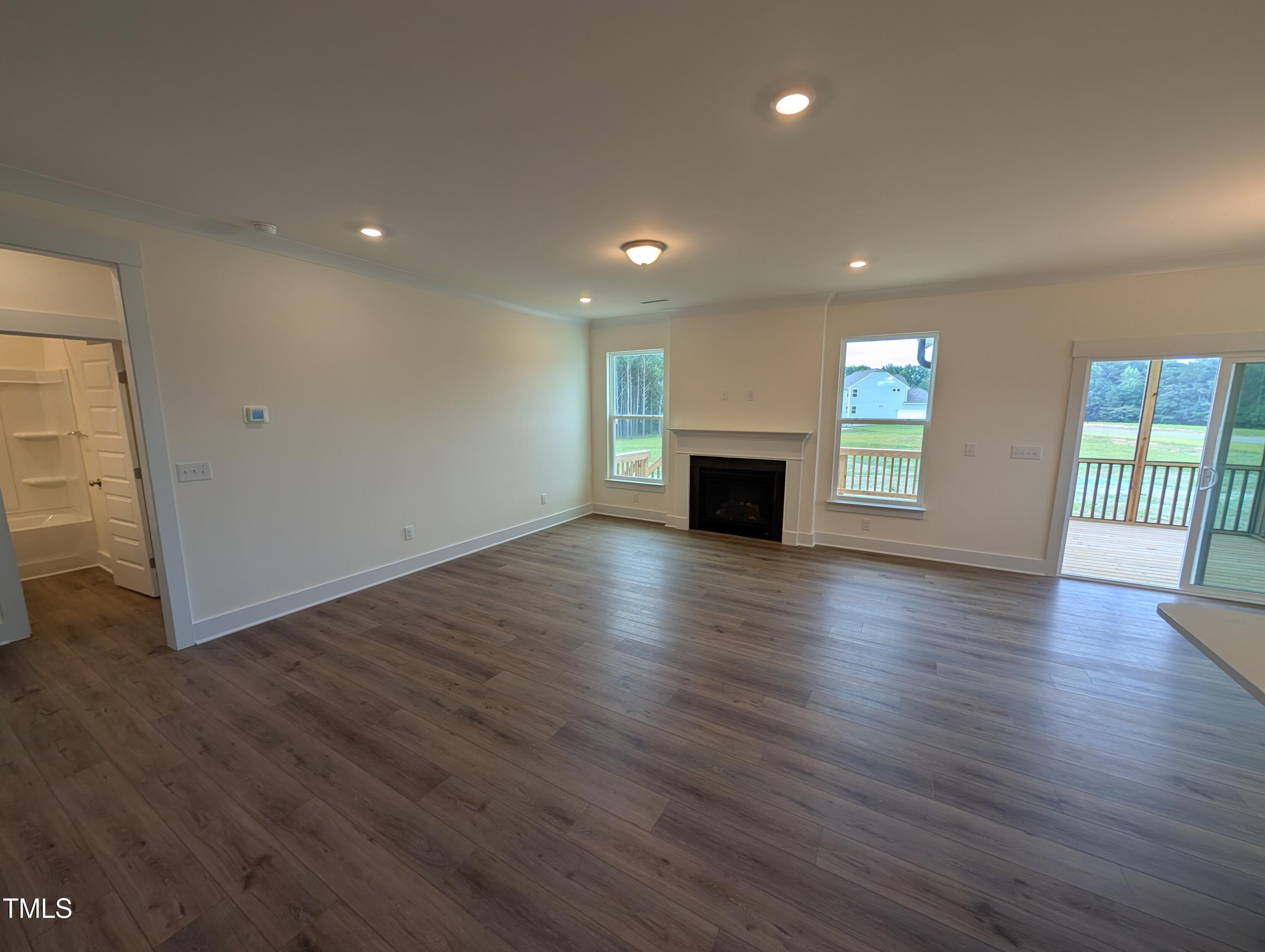 266 Weddington Way Benson, NC 27504 - Photo 7 of 35 an empty room with wooden floor and windows