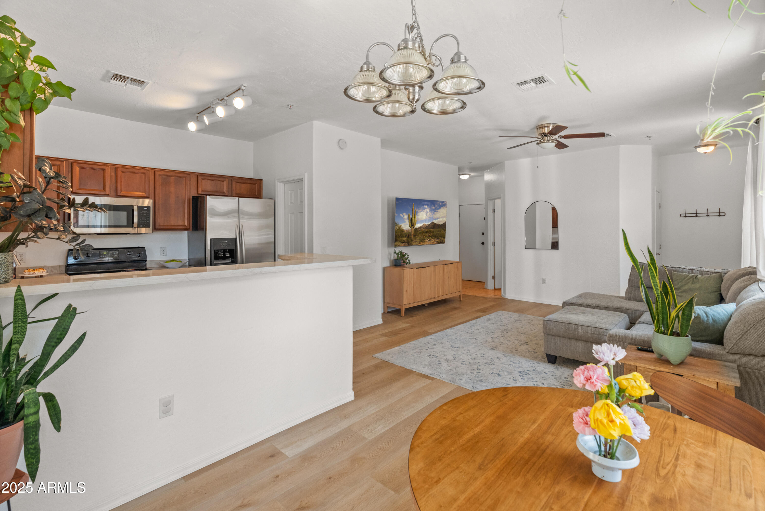 2150 East Bell Road, Unit 1088 Phoenix, AZ 85022 - Photo 5 of 25 a living room with kitchen island furniture and a chandelier