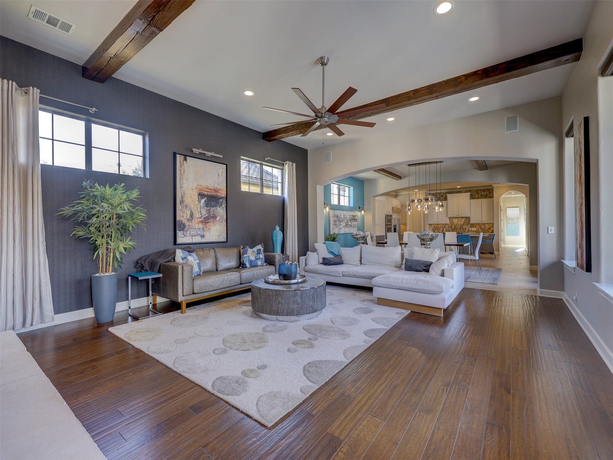 11805 Pleasant Panorama View Austin, TX 78738 - Photo 11 of 40 The living space has the perfect balance of rustic warmth and modern sophistication. This expansive living area is accented by massive dark wood beams. The dramatic charcoal accent wall provides a gallery like backdrop for your finest art pieces, while natural light pours in through oversized picture windows.
