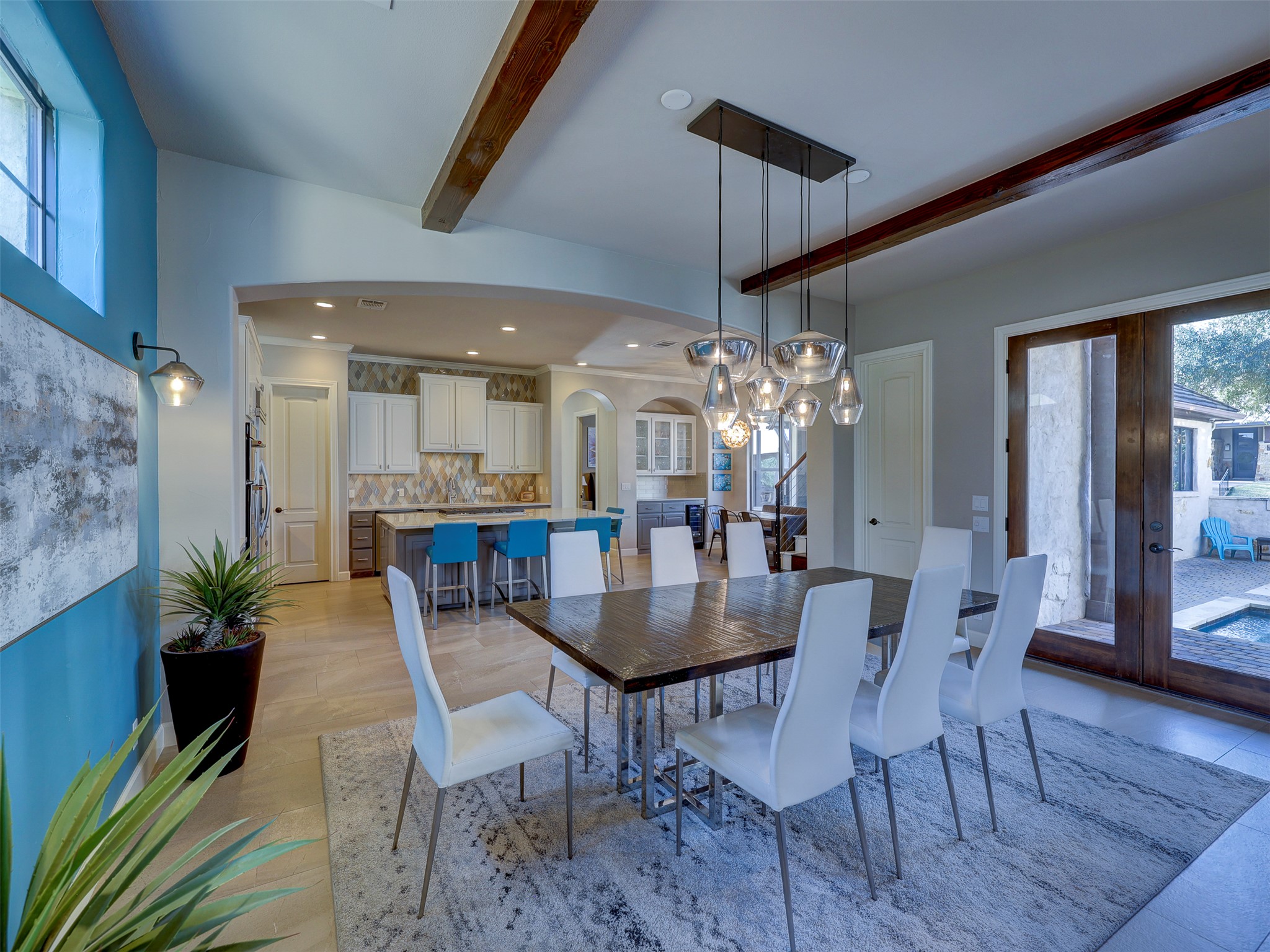 11805 Pleasant Panorama View Austin, TX 78738 - Photo 12 of 40 Elevate every meal in this elegant dining space. Centered under a stunning multi-pendant glass chandelier, the room offers a view of the poolside oasis through massive French doors.
