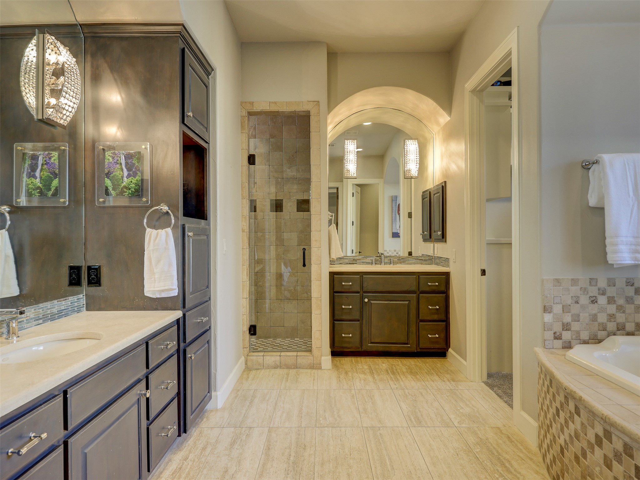 11805 Pleasant Panorama View Austin, TX 78738 - Photo 20 of 40 Start your morning at this elegant vanity with high end cabinetry in a deep espresso finish, complemented by a dramatic arched mirror and shimmering crystal sconces.