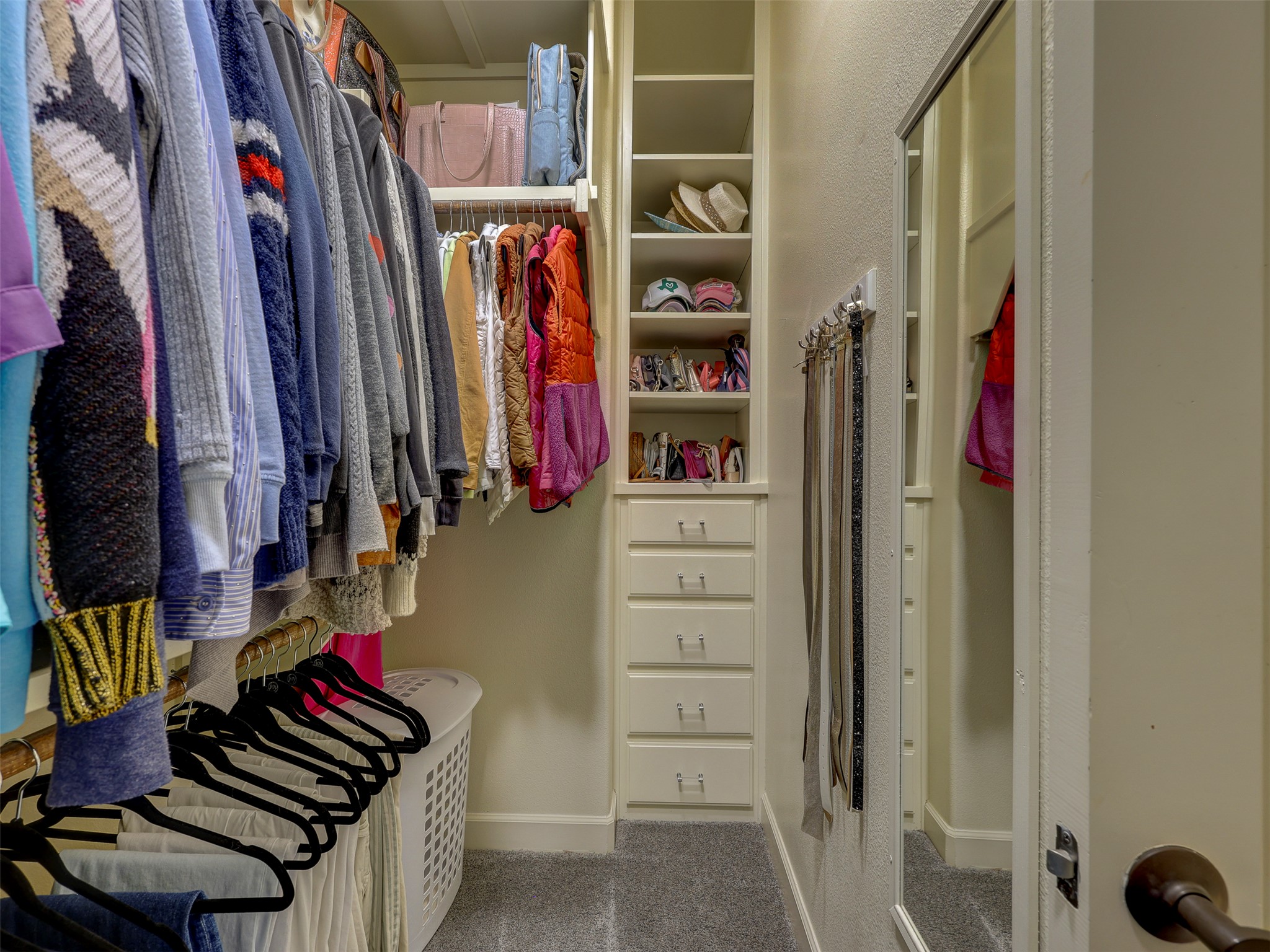 11805 Pleasant Panorama View Austin, TX 78738 - Photo 24 of 40 Organization is elevated in these expansive walk-in closets. Featuring floor-to-ceiling custom shelving, integrated dresser drawers, and dedicated shoe galleries, these spaces are designed to showcase a professional wardrobe with ease.