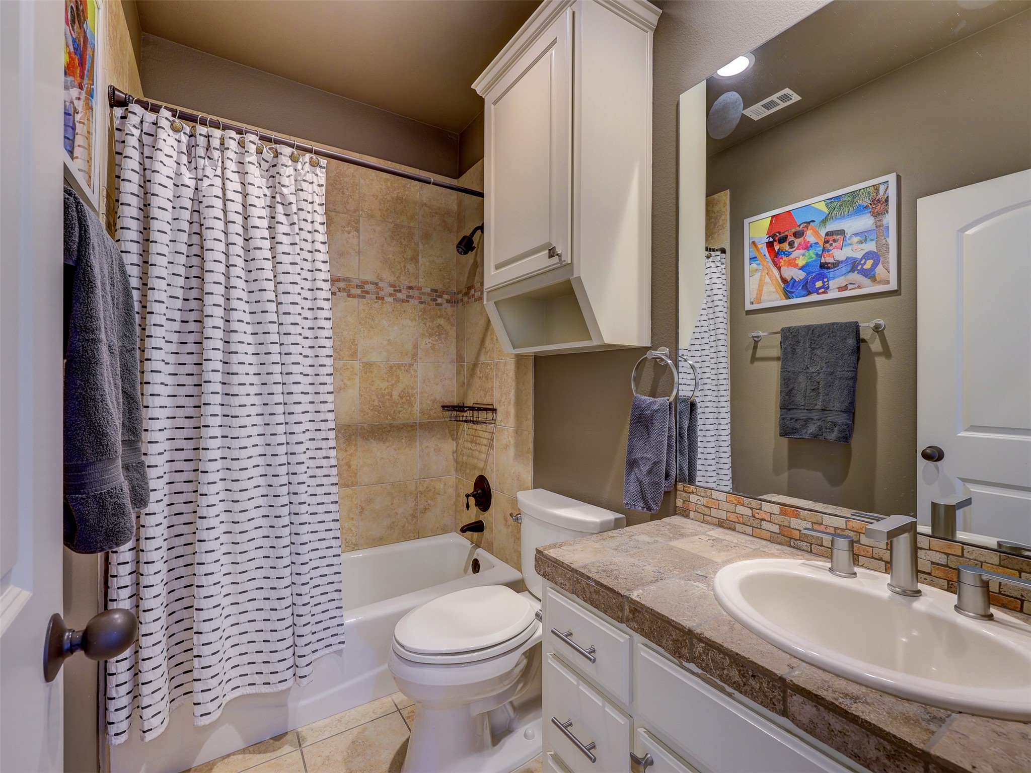 11805 Pleasant Panorama View Austin, TX 78738 - Photo 26 of 40 The guest accommodations are served by a stylishly appointed bathroom featuring a travertine-style tiled vanity and matching shower surround.