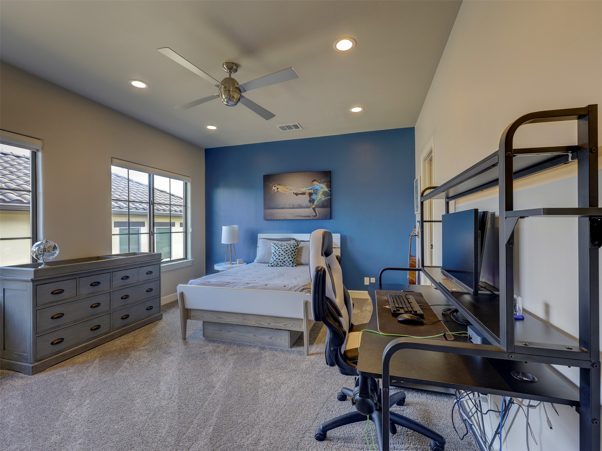 11805 Pleasant Panorama View Austin, TX 78738 - Photo 27 of 40 This bright and airy secondary bedroom is a versatile retreat, featuring a bold cobalt blue accent wall and recessed lighting.