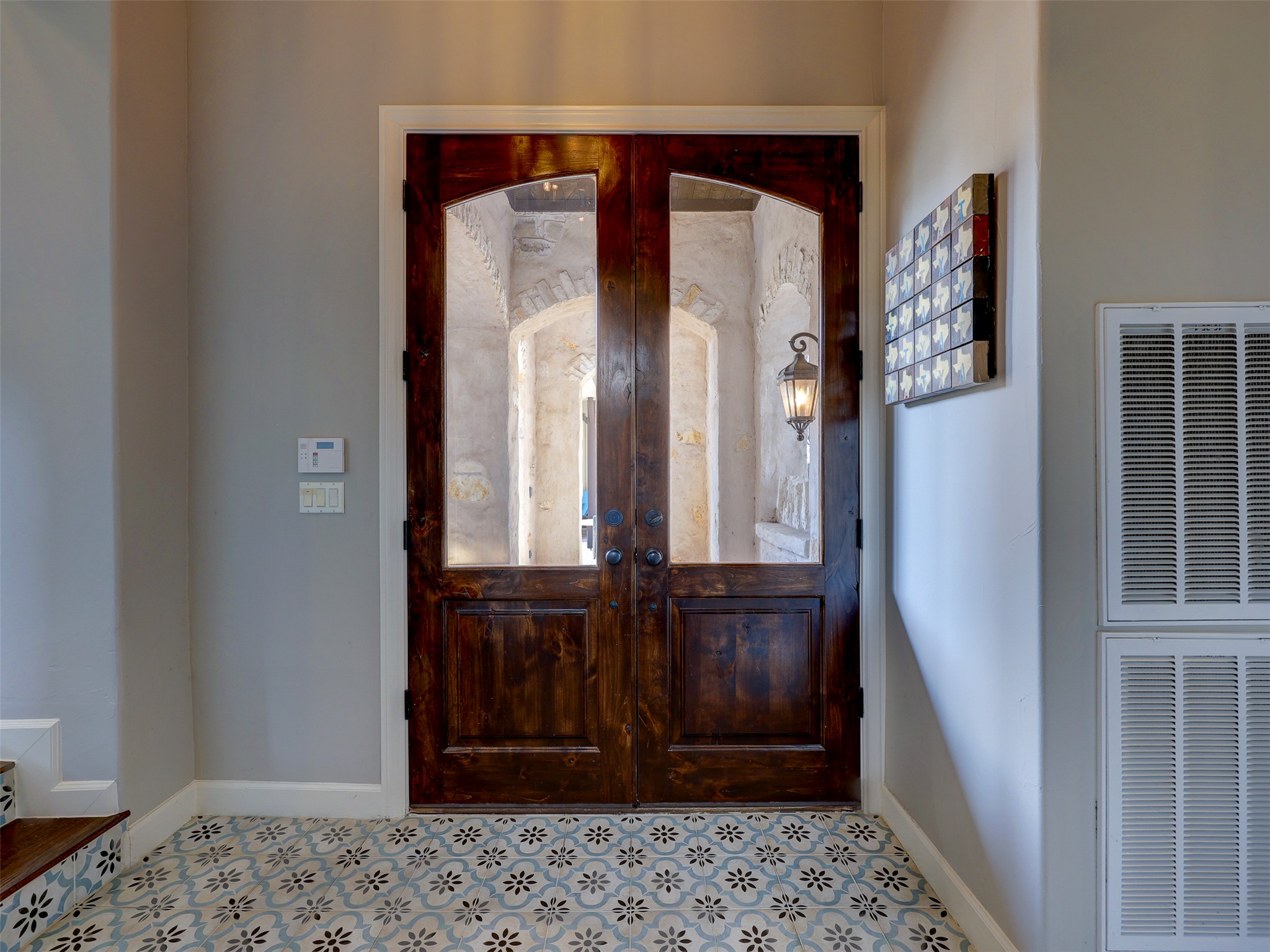 11805 Pleasant Panorama View Austin, TX 78738 - Photo 6 of 40 First impressions are everything. This inviting transition space features striking tile work on the risers and floor, beautifully contrasted by heavy-grained custom wood doors.
