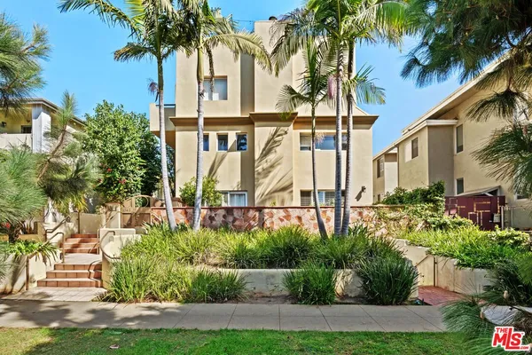 a view of a palm trees front of house