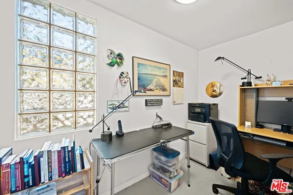 a view of a workspace with furniture and a window